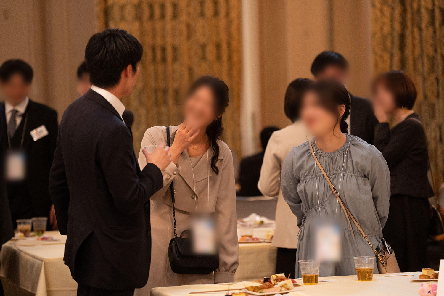 きらびやかな雰囲気の会場でテーブル越しに談笑する男女