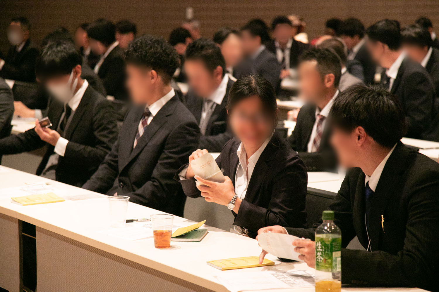 ステージ上で照明に照らされながら表彰状を掲げる男女複数名