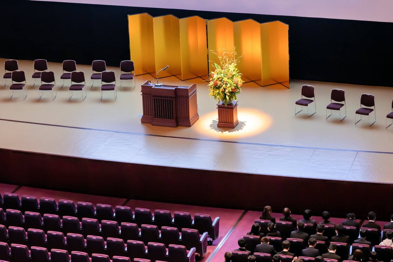 入社式のステージに演台と椅子と花
